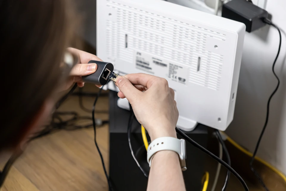 Homme d'affaires en veste militaire verte travaillant en ext&eacute;rieur sur ordinateur portable, t&eacute;l&eacute;phonant avec smartphone