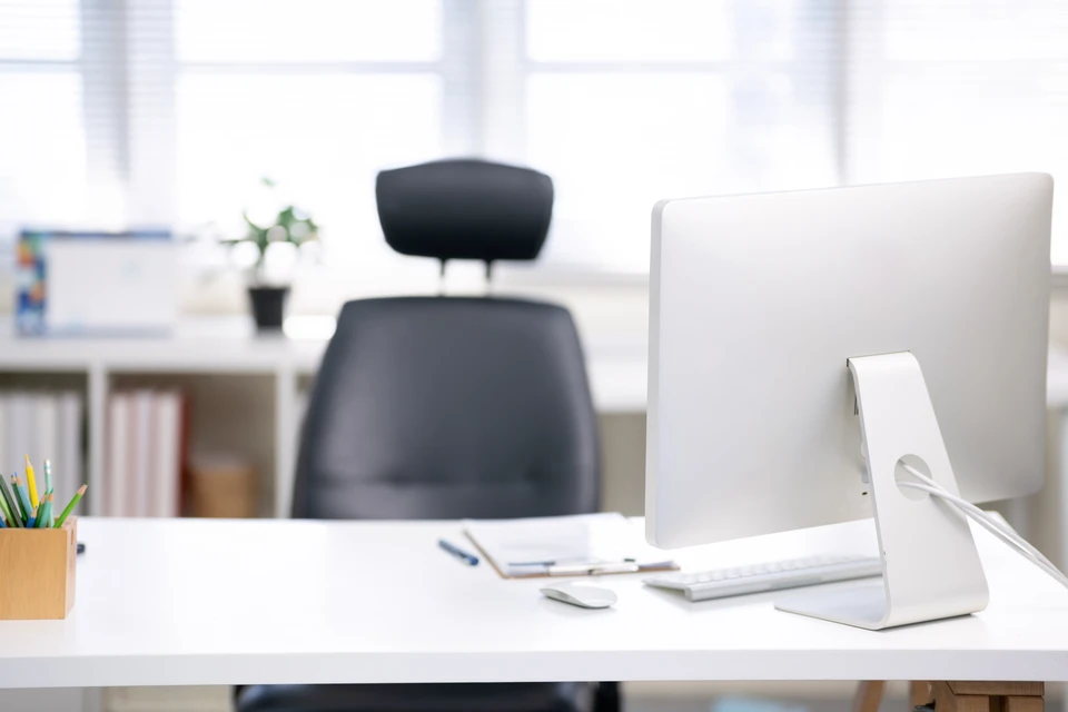 Espace de travail moderne avec ordinateur portable argenté ouvert, écran blanc vierge, clavier noir