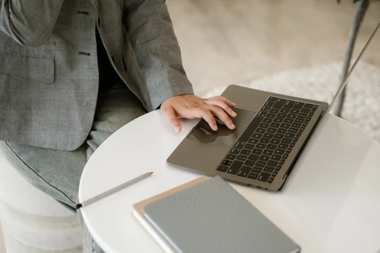 Jeune femme travaillant sur ordinateur portable dans caf&eacute; moderne, concentr&eacute;e devant l'&eacute;cran, verre &agrave; proximit&eacute;